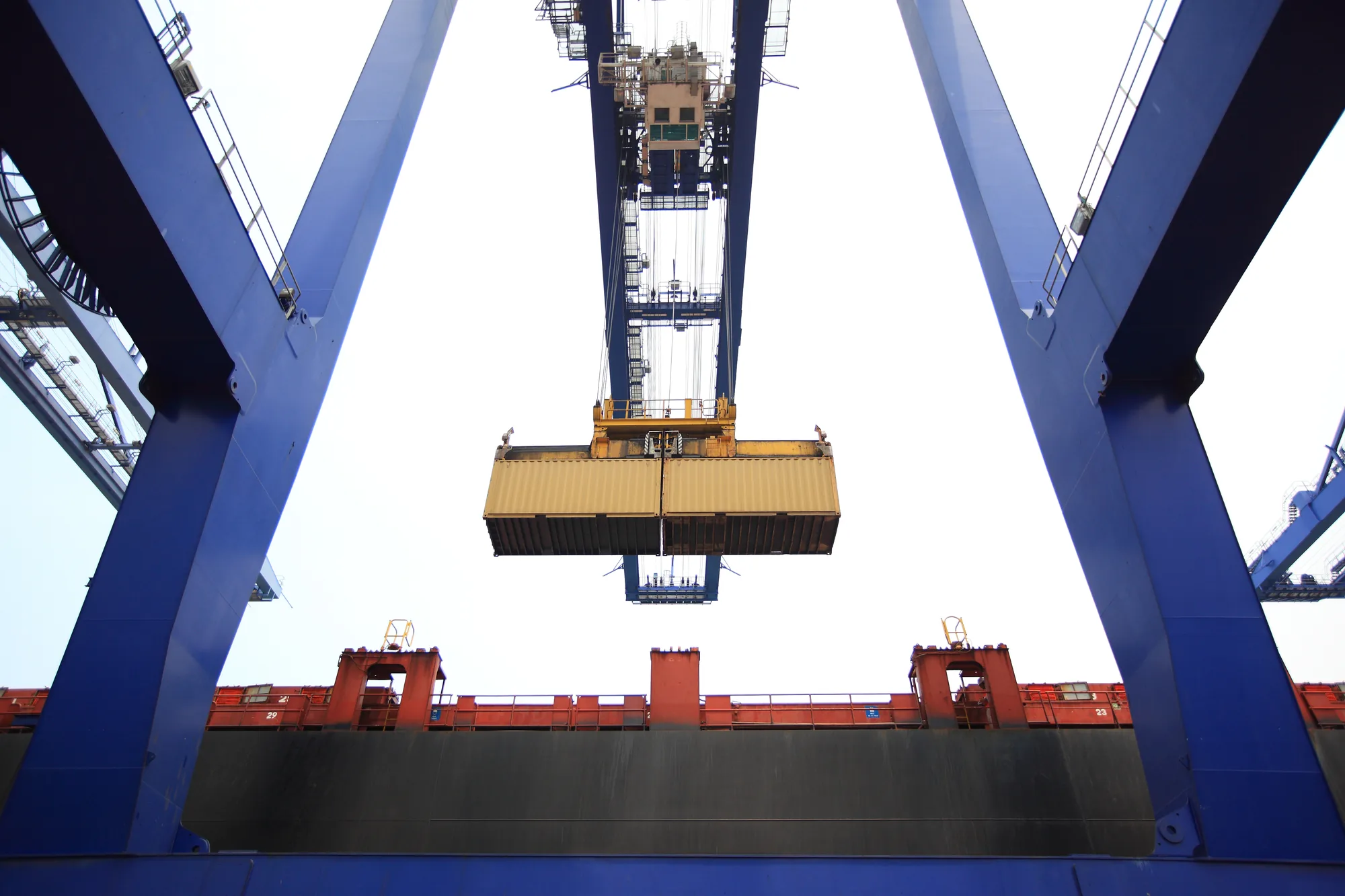 A gantry crane lifting a container above the quay